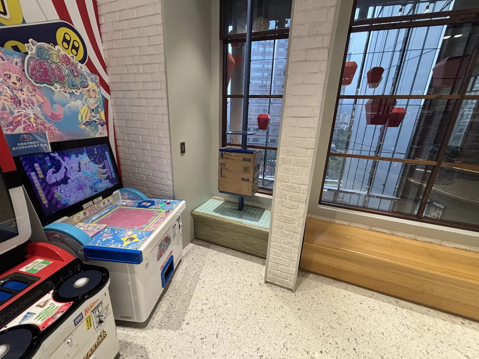 ゲームセンターの機械、吹き抜け、窓外の建物が写るarcadeの問題画像